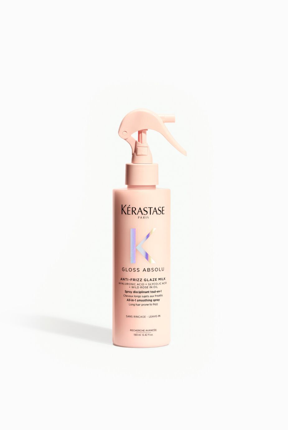 A pink spray bottle of Kerastase Gloss Absolu, an anti-frizz glaze milk for hair, displayed against a plain white background.