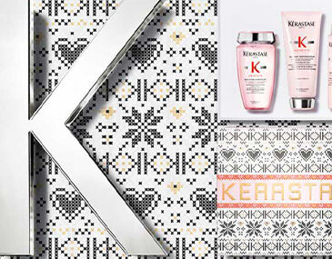 A close-up of a silver letter "K" set against a patterned background featuring hearts and geometric designs, alongside two Kerastase hair care products in pink bottles.