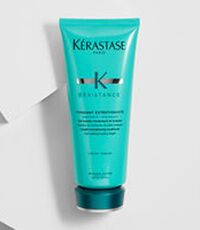 A turquoise tube of Kerastase Resistance hair conditioner, promoting strength and length for healthy hair.
