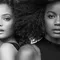 A black and white portrait of two women standing back to back, showcasing different hairstyles—one with wavy hair and the other with voluminous curls. Both have natural makeup, highlighting their features.