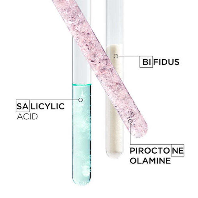 Alt text: Three test tubes containing different substances: one with salicylic acid (light blue liquid), one labeled bifidus (white solid), and one with piroctone olamine (pink crystalline substance).
