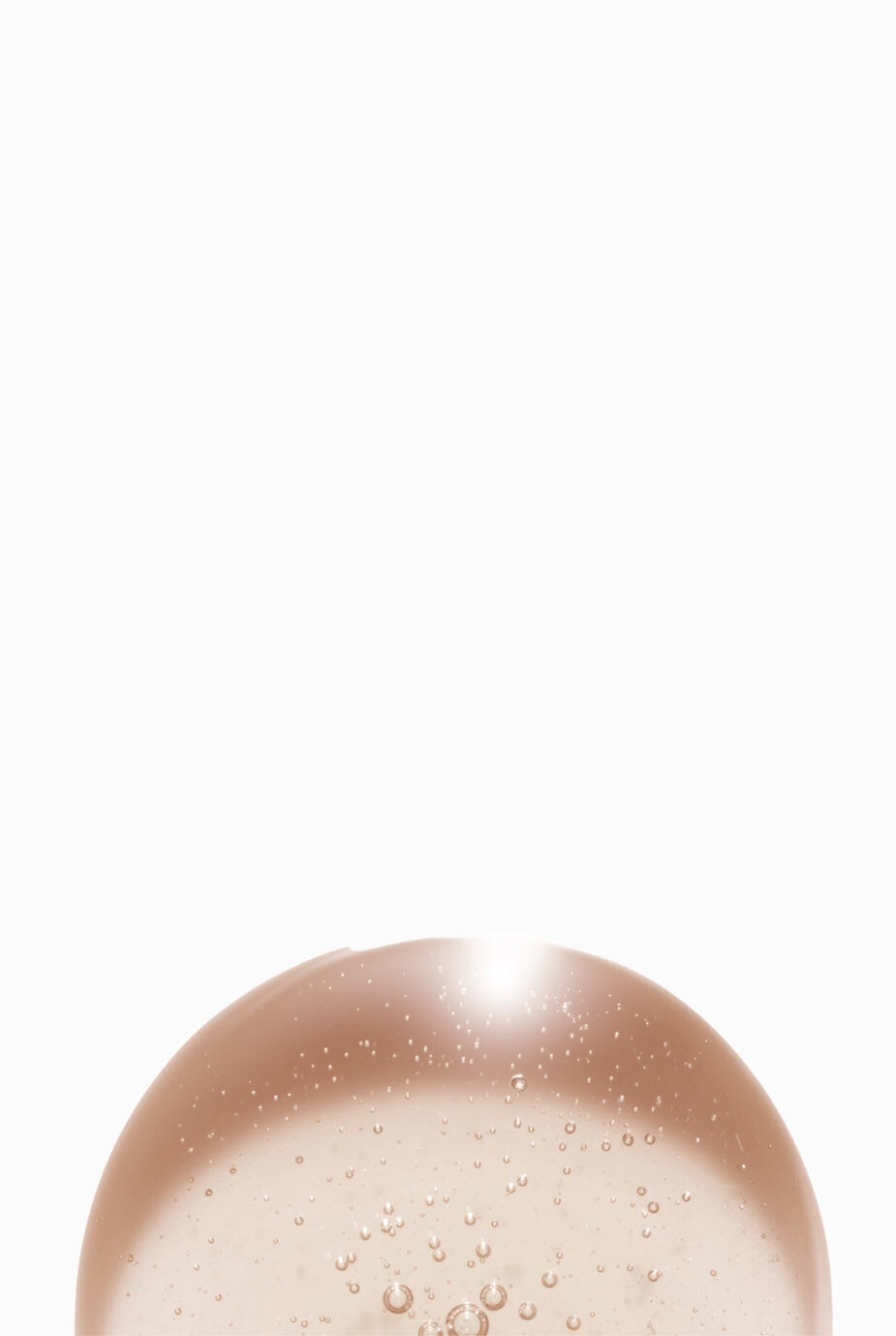 A close-up view of a smooth, translucent gel-like substance with small bubbles, set against a plain white background.