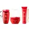 Three Kerastase hair care products are displayed against a light background. The products include a shampoo, a hair mask, and a leave-in treatment, all in vibrant red packaging.