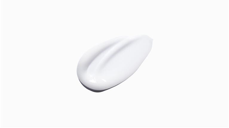 A smooth, white cream or lotion blob on a light background, showcasing its silky texture.