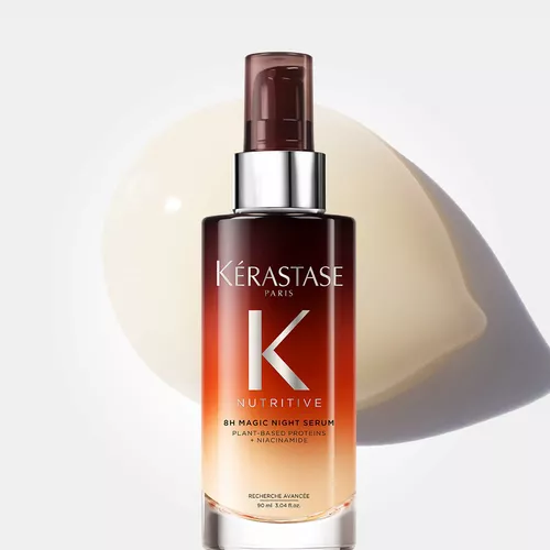 Bottle of Kerastase 8H Magic Night Serum with a creamy texture background, showcasing a nourishing hair care product.