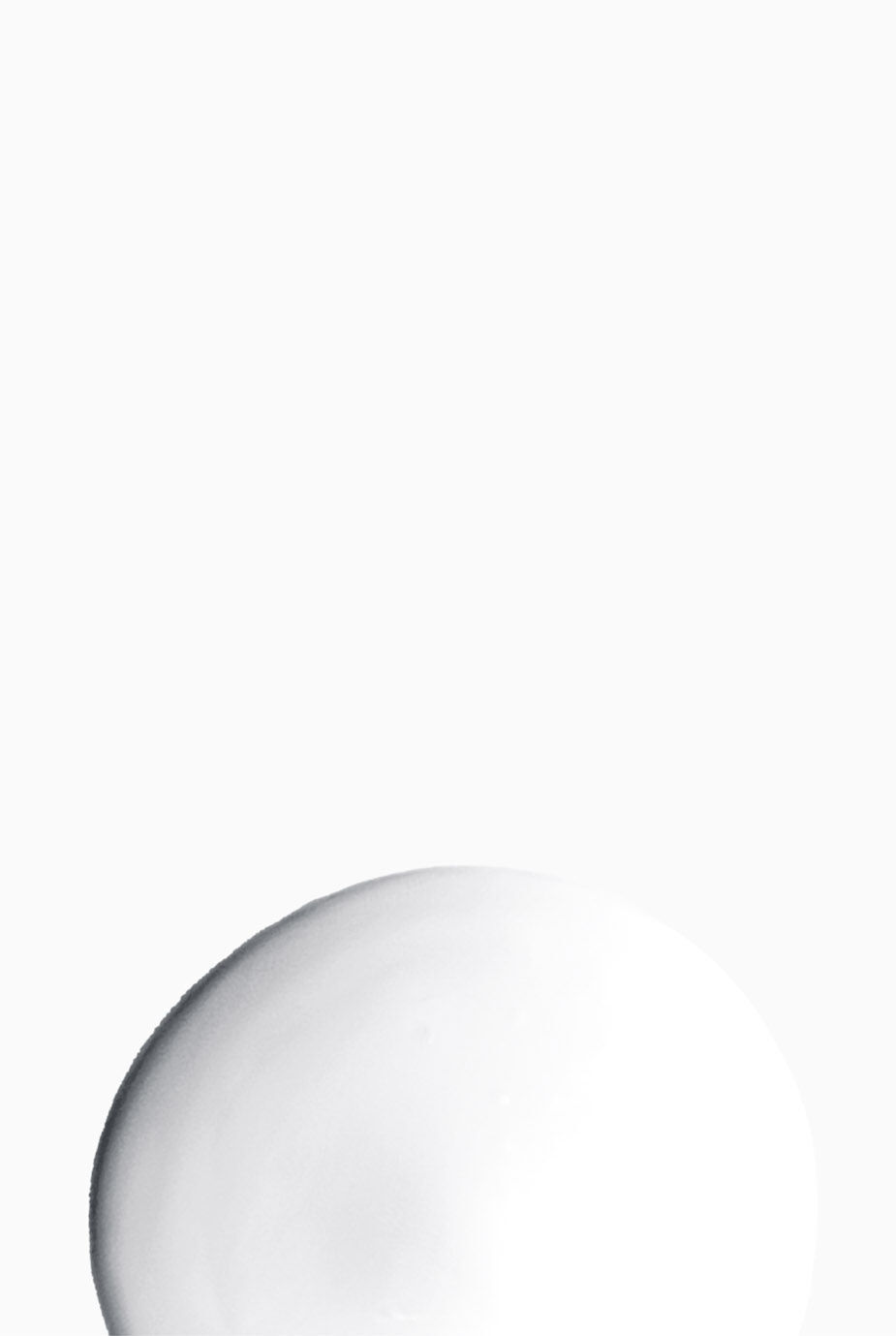 A smooth, white spherical object sits in the lower portion of a plain white background.