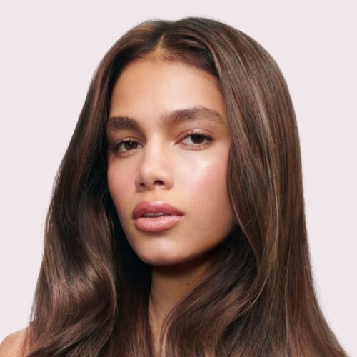  A woman with glossy hair on a light brown background