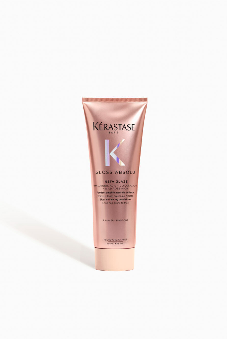 A tube of Kerastase Gloss Absolu Insta Glaze hair treatment, featuring a sleek pink design with black text, on a plain white background.
