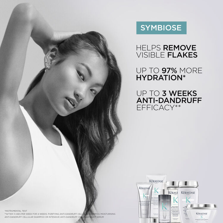 A stylish model poses confidently, showcasing hair care products from the Symbiose line by Kerastase, which promises to help remove visible flakes, increase hydration, and provide up to three weeks of anti-dandruff efficacy.