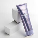 Kerastase Blond Absolu Cicaflash conditioner resting against white blocks with a grey background​