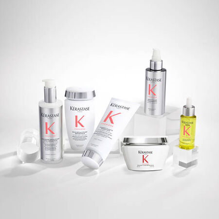A collection of Kerastase hair care products, including shampoos, conditioners, and serums, displayed on a light gray background.