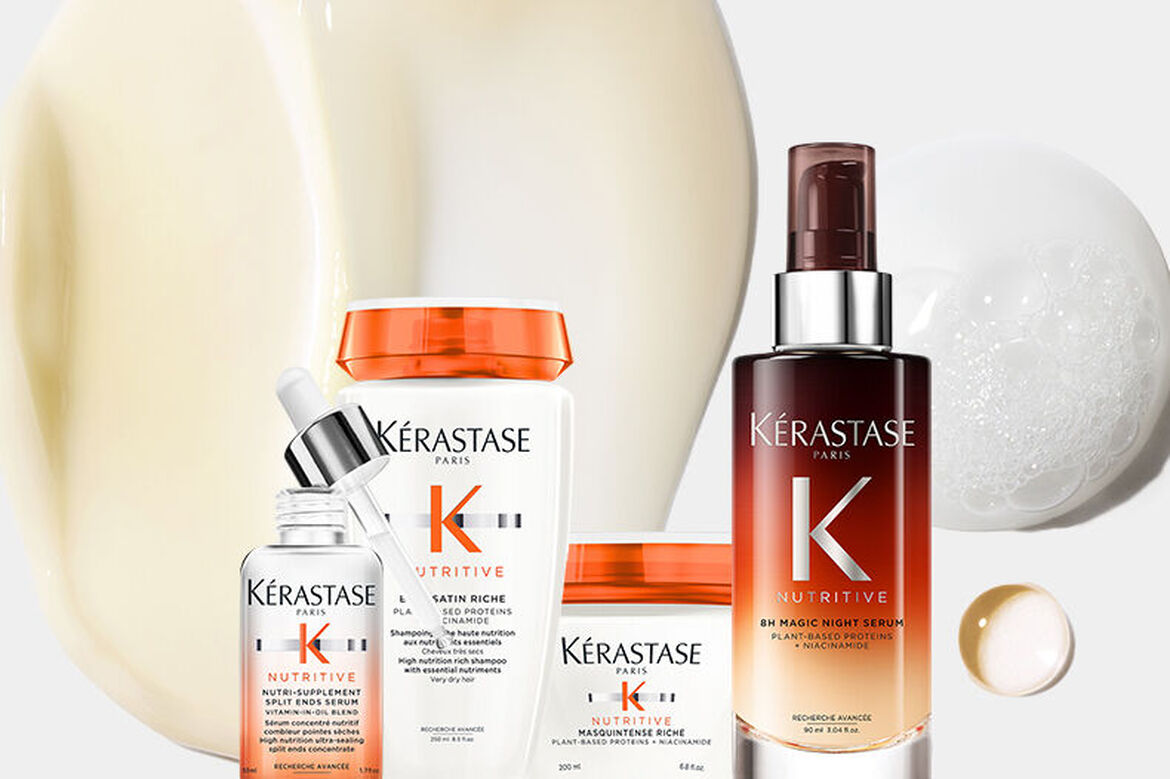 A collection of Kerastase hair care products arranged next to various textures of creams and serums on a light background.
