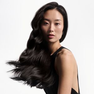 A person with the results of healthy hair following an anti-breakage haircare routine
