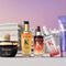 A selection of Kerastase hair care products displayed in front of a stylized background featuring architectural elements. The products include a black jar, various serums, and a purple tube, all prominently labeled with the Kerastase logo.