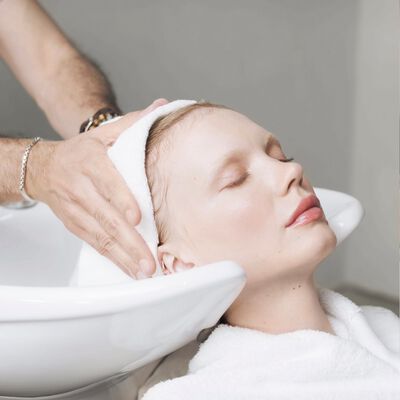 :A woman gently towel drying hair to avoid damage and get shiny hair