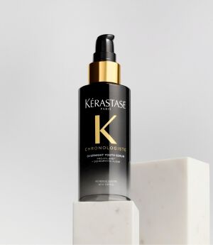 SHOT OF A BLACK AND GOLD BOTTLE ON A PODIUM