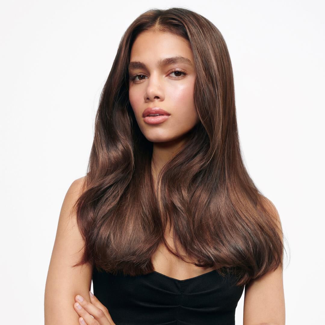 A woman showcasking her smooth, shiny and bouncy hair after using Gloss Absolu hair glaze