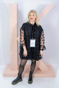 Kerastase Care Coach Ellie O'Donovan standing in front of a Kerastase letter K sign