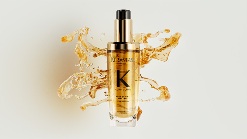 Kerastase Elixir Ultime Original Hair Oil A luxurious Kerastase hair elixir bottle, surrounded by splashes of golden oil, showcasing its premium quality.