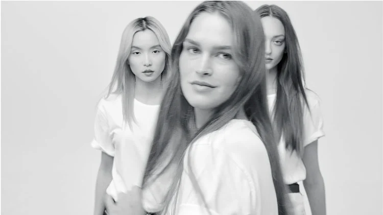 Kerastase Fusio-Dose In-Salon Hair Routine Three models with long hair wearing white shirts, posing against a plain white background in a fashion shoot.