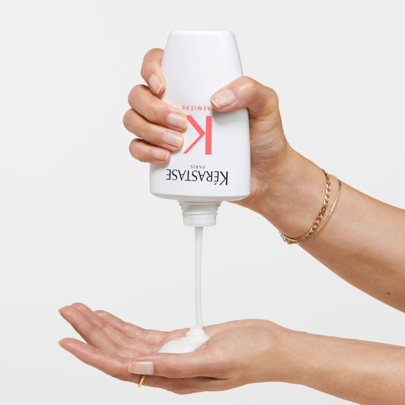 hands holding Gloss Absolu bain Hydra-Glaze Shampoo, lathering the sides of the bottle.
