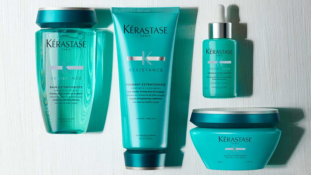 Four Kérastase hair care products in turquoise packaging, including shampoo, conditioner, serum, and mask.