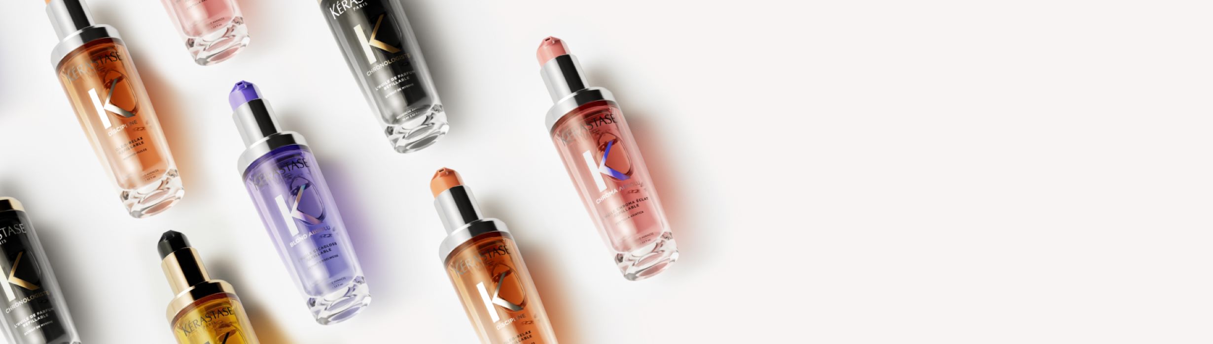 A flat lay of various serum bottles in different colours, arranged on a light background, highlighting a skincare collection.